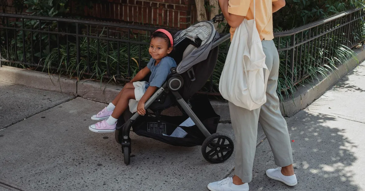 Mother holding her child while applying for child tax benefit loans on a phone