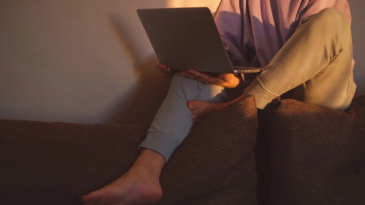 Person completing an application for e-transfer loans no verification on a laptop in the evening