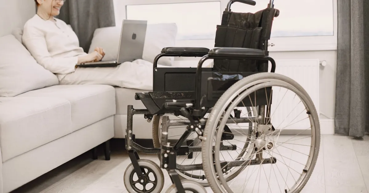 Person using a wheelchair applying for ODSP payday loans on a laptop at home